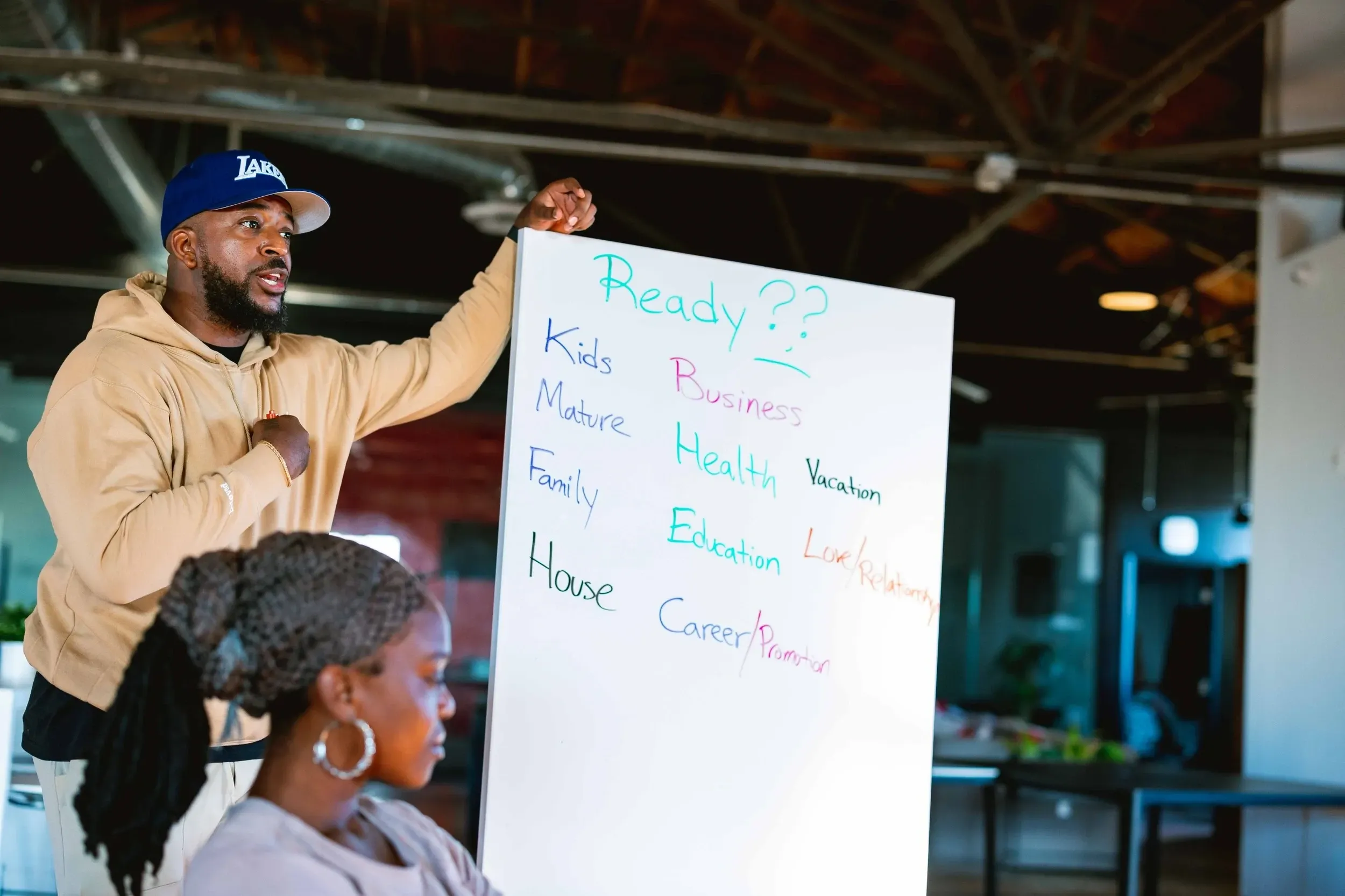 Facilitator writing financial goals on a whiteboard at a Healing Circle LA financial literacy and wealth building workshop in Los Angeles